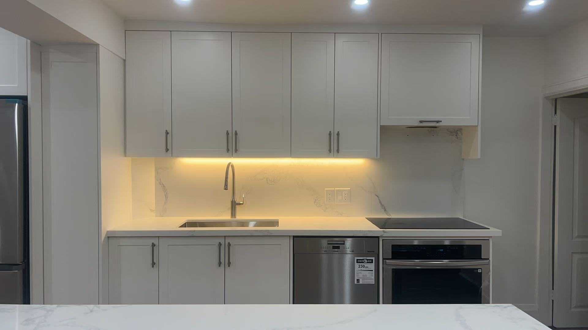 Linear White Shaker kitchen cabinet with striped light above the